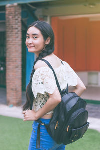 Portrait of smiling young woman standing outdoors