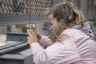 Side view of woman using mobile phone