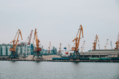 Bulk carrier ship under load of clinker cargo loading by shore cranes with grabs. sea trading port 