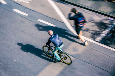 High angle view of man riding bicycle on city street