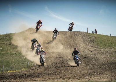 People riding motorcycle on field