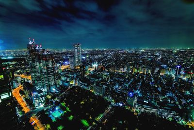 Illuminated cityscape against sky at night