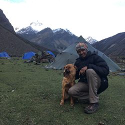 Portrait of man with dog on field