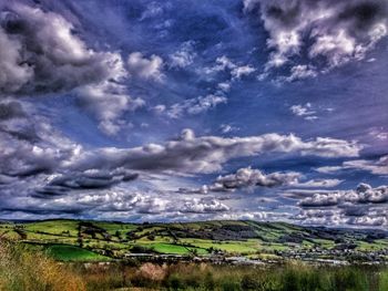 Scenic view of field against cloudy sky