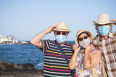 Portrait of family wearing mask while standing against sky