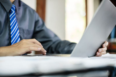 Midsection of businessman working at office