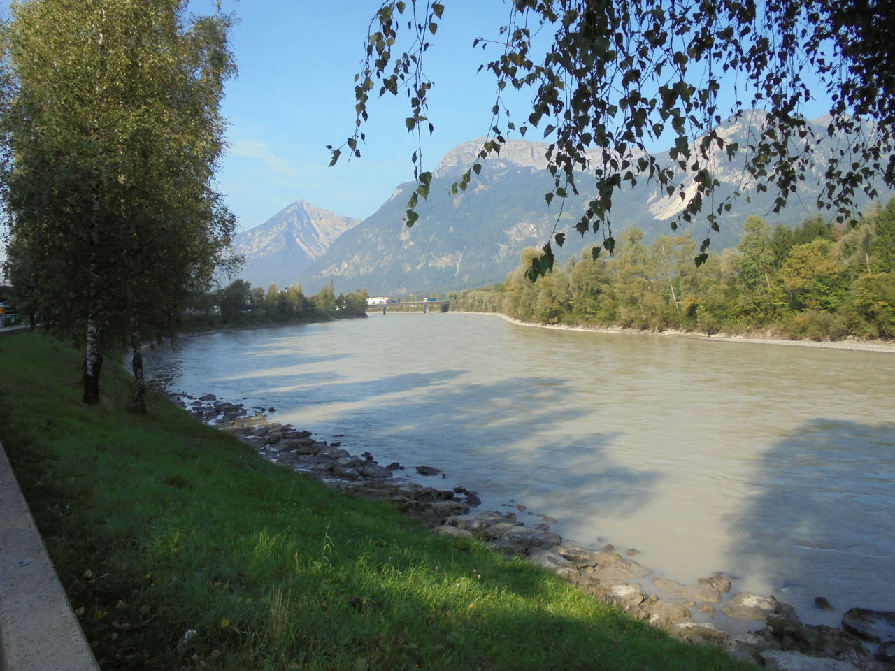 mountain, tree, tranquil scene, tranquility, water, scenics, grass, mountain range, river, beauty in nature, nature, non-urban scene, clear sky, travel destinations, idyllic, remote, day, solitude, branch, growth, countryside, green color, blue, majestic, outdoors, riverbank, no people, tourism