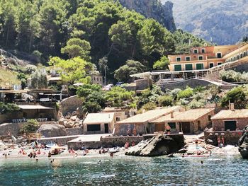 People on boats by sea against buildings