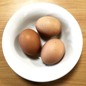 Directly above view of brown eggs in plate on table