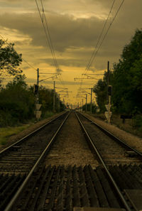 Railroad tracks against sky at sunset