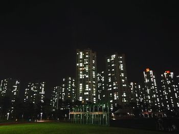 Low angle view of illuminated city against sky at night