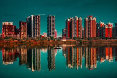 Reflection of buildings in lake against sky