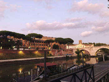 Bridge over river against buildings in city