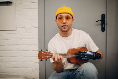 Portrait of young man playing guitar