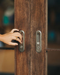 Close-up of human hand on door