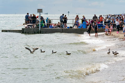 People at beach against sky