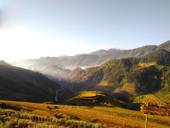 Scenic view of field and mountains against sky