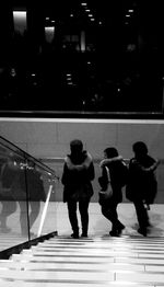 Woman walking in illuminated city at night