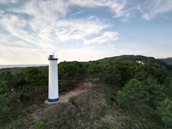 Lighthouse by sea against sky