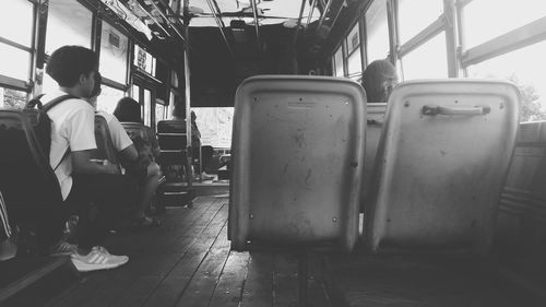 Rear view of man sitting on seat in bus