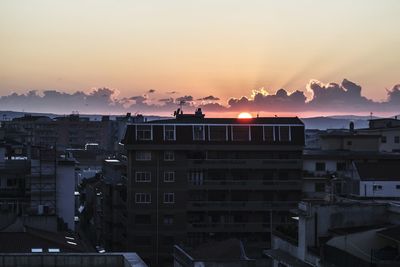 Panoramic shot of cityscape against sky during sunset