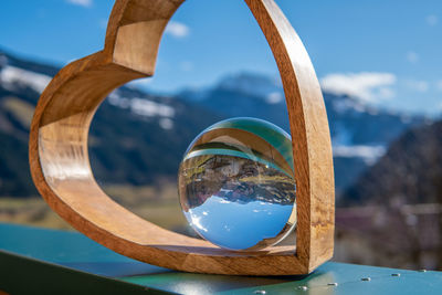 Close-up of reflection on table against sky