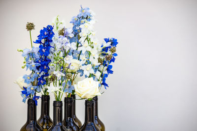 Close-up of purple flowering plant in vase against white background