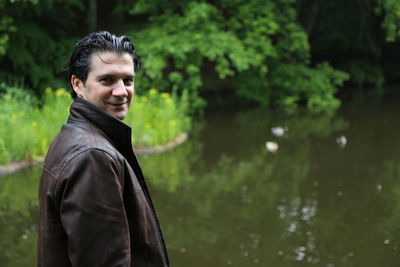 Portrait of man standing against lake