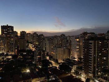 Exterior of illuminated buildings against sky in city