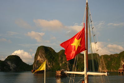 Scenic view of flag by sea against sky