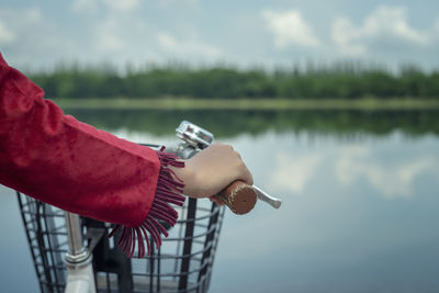 Person holding umbrella by lake