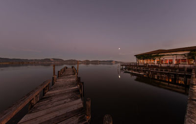 Pier over lake against sky at night