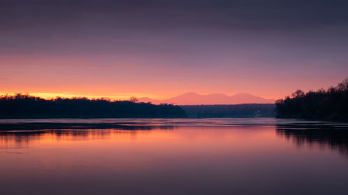 Scenic view of river against sky during sunset