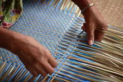 Cropped hands making wicker art