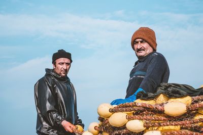 Portrait of happy man with food against sky