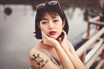 Portrait of beautiful young woman with tattoo on her arm