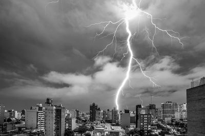 Forked lightning over cityscape against dramatic sky
