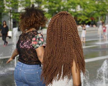 Friends walking by fountain on sunny day