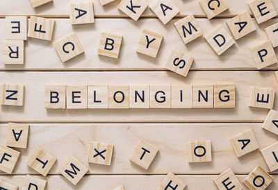 Word belonging made with letter blocks on wooden background