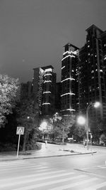 Low angle view of illuminated buildings against sky at night