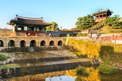 Arch bridge over river against buildings