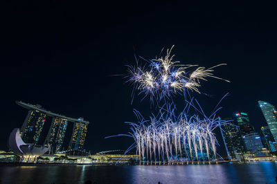 Firework display over river at night