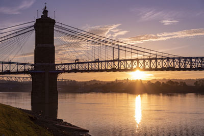 View of bridge over river at sunset