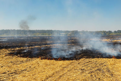 Smoke emitting from volcanic landscape against sky