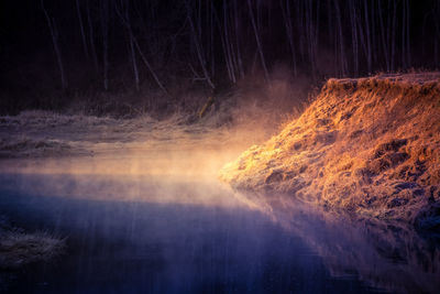 Scenic view of waterfall in forest at night