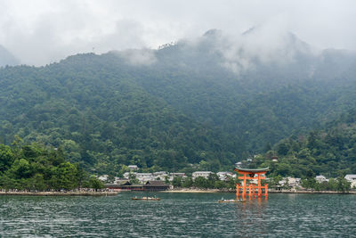 Scenic view of river by mountains against sky