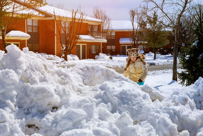 Man working on snow covered tree by building