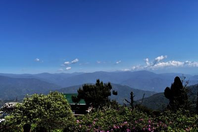 Scenic view of mountains against blue sky