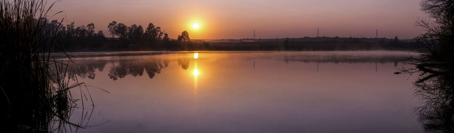 Scenic view of lake against sky during sunset