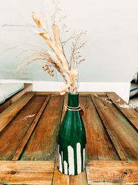 Close-up of plant in vase on table against wall